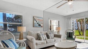 Un salon moderne avec un canapé, des fauteuils, une table basse et des œuvres d’art accrochées au mur.