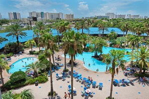 Un complexe hôtelier doté de plusieurs piscines, de palmiers et d’espaces de détente.