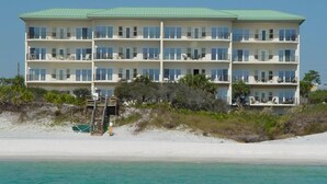 A multi-story hotel with balconies, located on a beach with clear turquoise water. - Legacy 506- The Coastal Gem (Santa Rosa Beach)