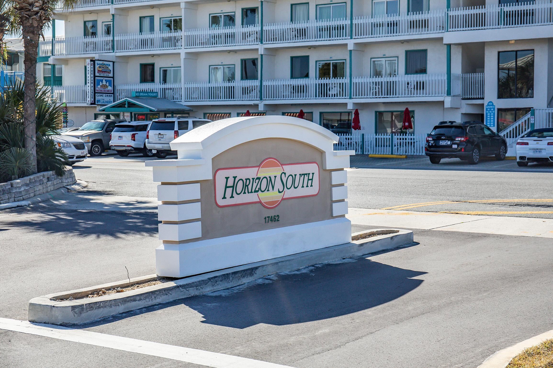 A hotel sign with 'Horizon South' and a number '17462' on a building.