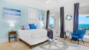 Ein Schlafzimmer mit Bett, Nachttisch, Schreibtisch, Stuhl und Meerblick.
