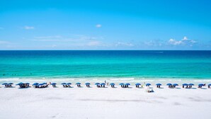 Ein Strand mit weißem Sand und türkisblauem Wasser.
