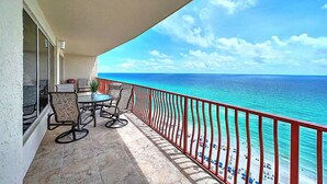 Ein Balkon mit Meerblick, einem Tisch mit Stühlen und einem Geländer.