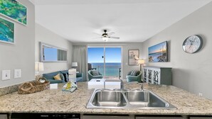 A modern kitchen with granite countertops, stainless steel sinks, and a built-in dishwasher.