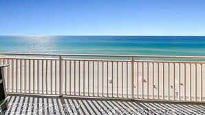 A balcony with a view of a beach and ocean.