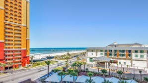 A hotel with multiple floors, a beach view, and a parking area with palm trees. - Calypso 3-504 (Panama City Beach)