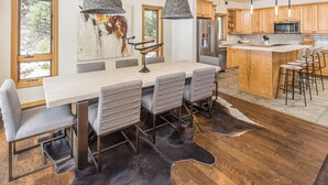 Una cocina moderna con armarios de madera, un refrigerador de acero inoxidable y una isla grande con taburetes de bar.