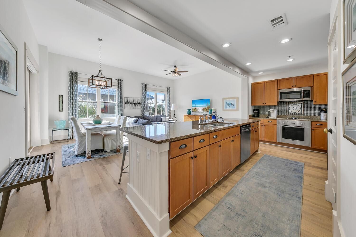 A modern kitchen with wooden cabinets, stainless steel appliances, and a large island.