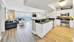 Een modern appartement met keuken, eethoek en woonkamer.