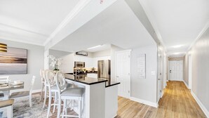 Een moderne keuken met witte kastjes, roestvrijstalen apparatuur en een centraal kookeiland.