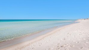 A wide sandy beach with clear turquoise water and a clear sky. - Belles Beach House (Panama City Beach)