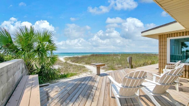 A wooden deck with outdoor seating and a view of the beach. - Belles Beach House (Panama City Beach)
