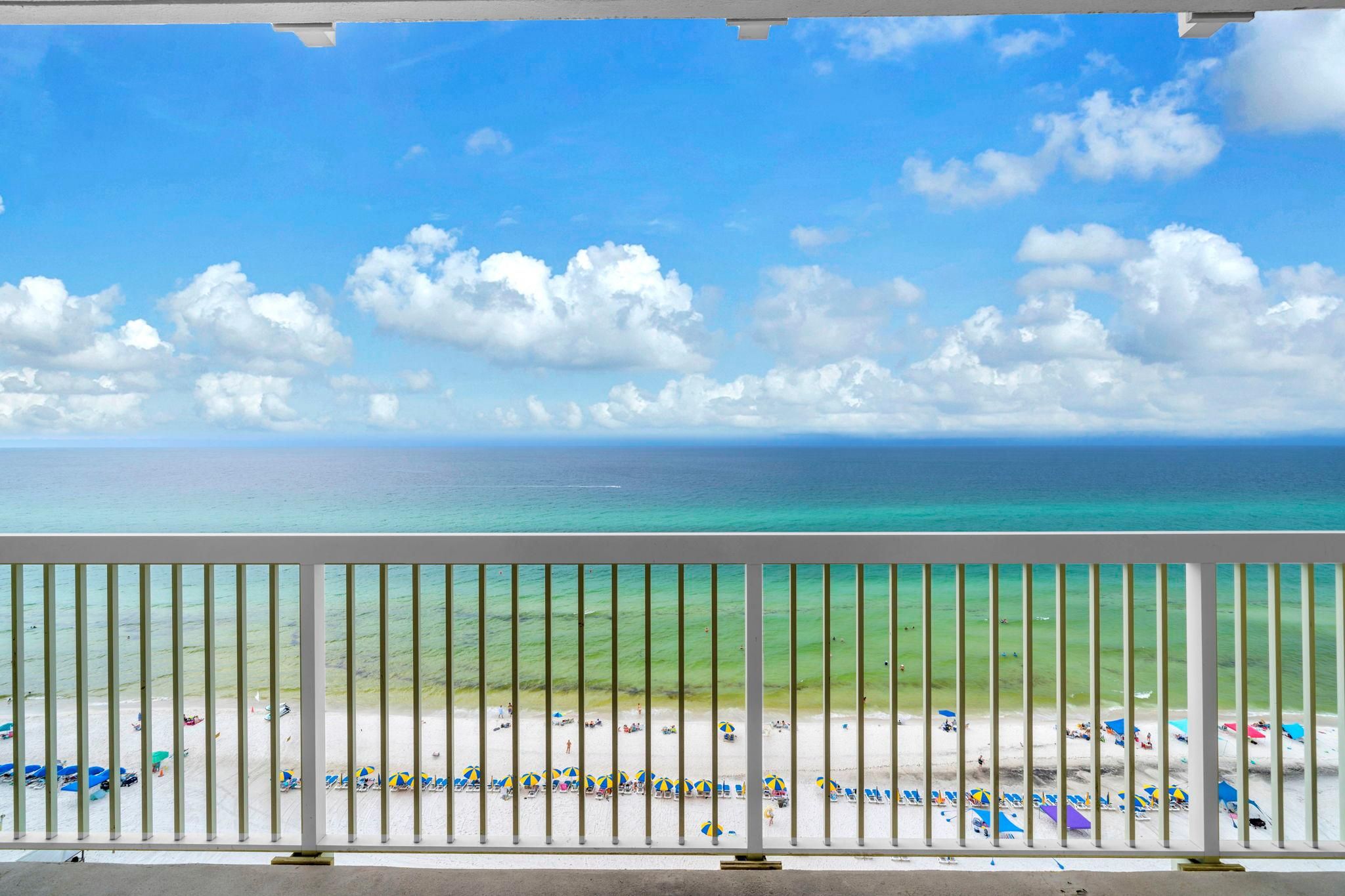 Un balcon avec vue sur une plage et l’océan.