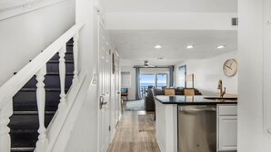 A modern kitchen with a dishwasher, a clock on the wall, and a view to the outside. - The Sand Trap- Costa del Sol C-9 (Miramar Beach)