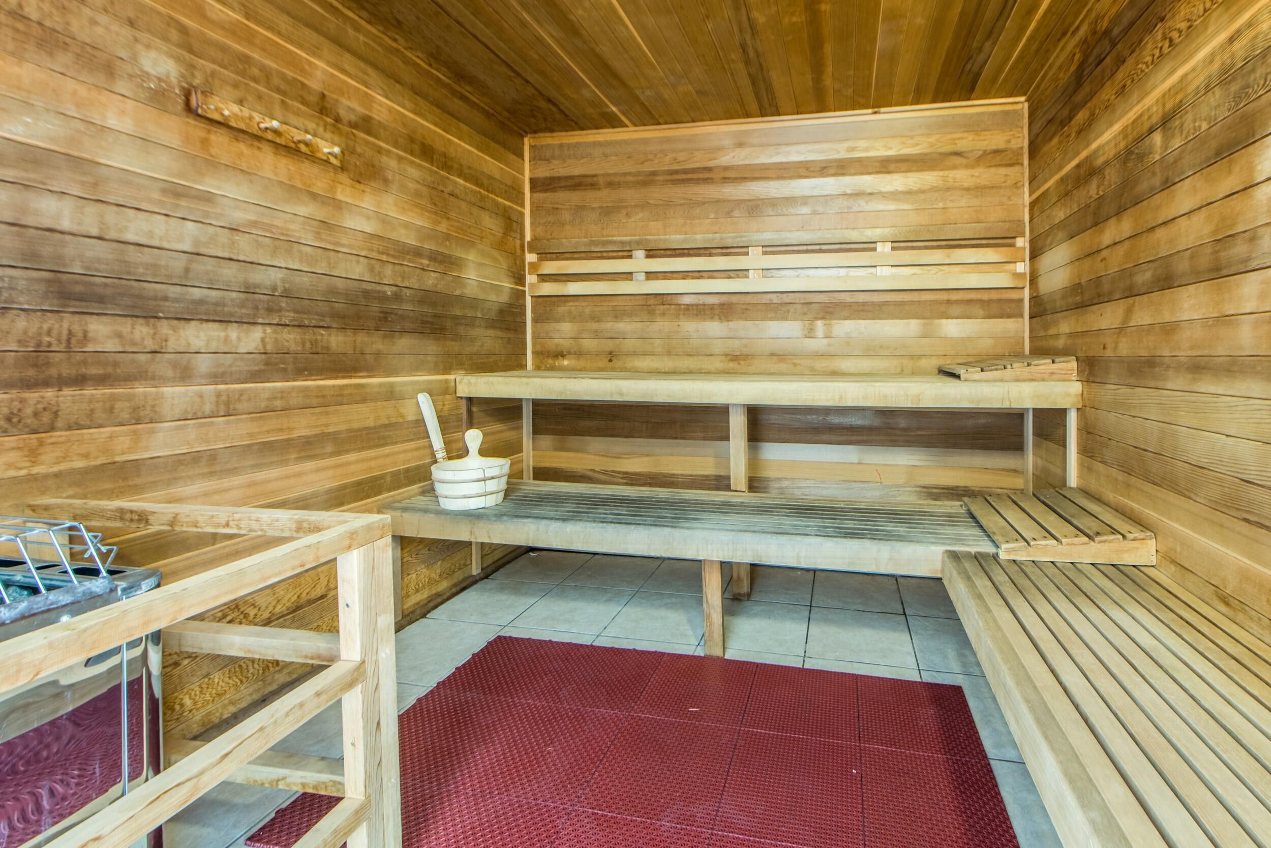 Uma sauna com bancos de madeira e um banco com suporte para toalhas.