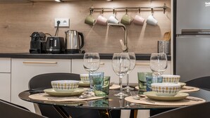 A modern kitchen with a dining table set for four, equipped with glassware and plates. - Upscale 3-room apartment, 300m from the beaches (Cannes)