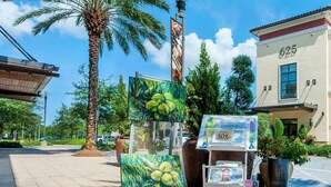 A building with the number 625, a palm tree, and artwork on display. - Pointe of View 407- Penn's Paradise (Miramar Beach)
