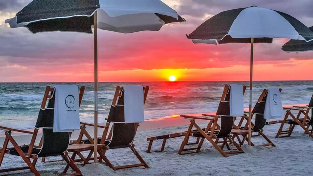 Beach chairs with umbrellas, a sunset view, and the ocean. - Pointe of View 407- Penn's Paradise (Miramar Beach)