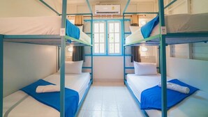 A room with bunk beds, a window with curtains, and an air conditioning unit. - Bodega Koh Phi Phi (Ko Phi Phi)