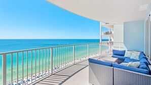 A balcony with a view of the beach and ocean.