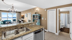 A modern kitchen with granite countertops, stainless steel appliances, and a view to the outside. - Ariel Dunes I 1404 (Miramar Beach)
