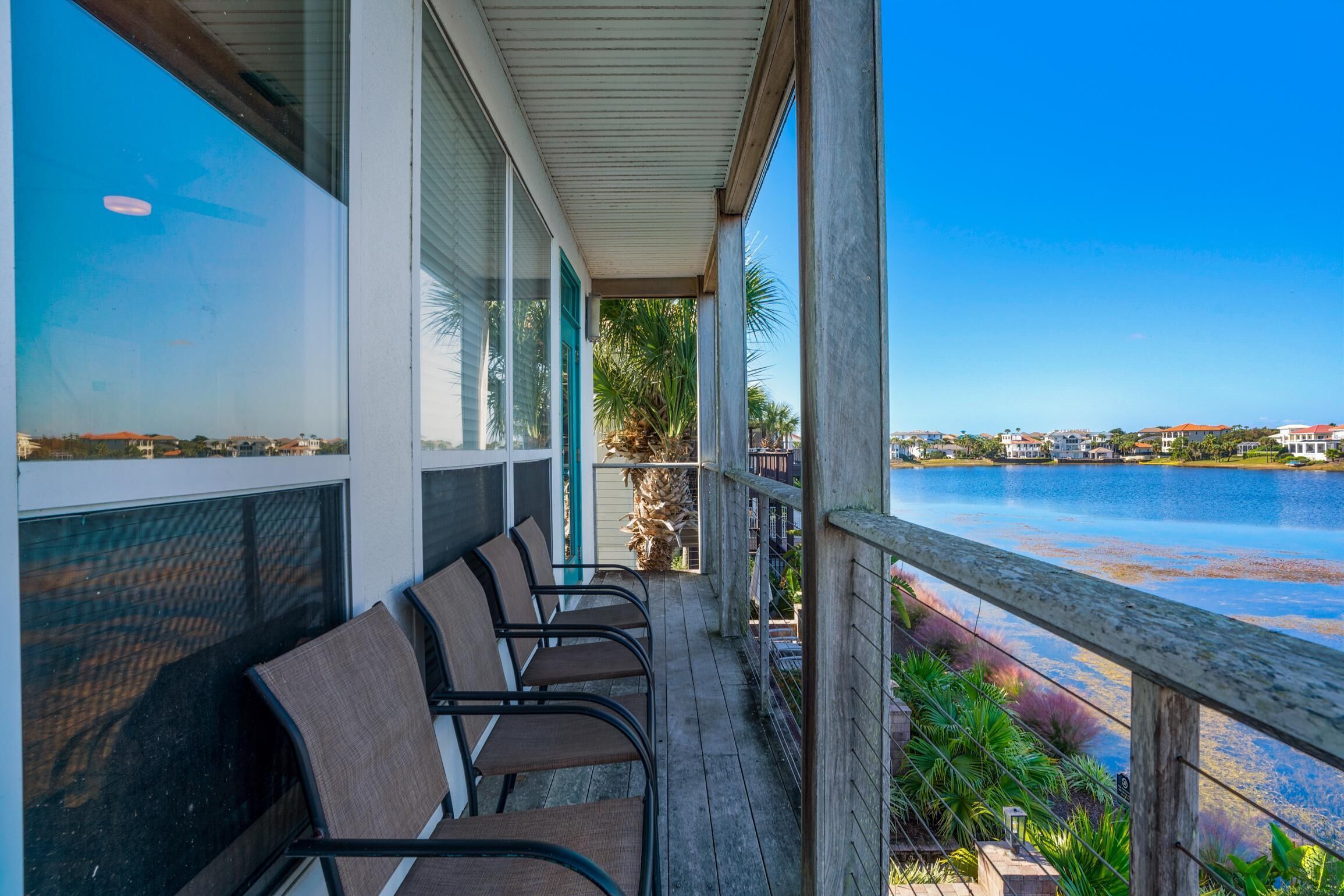 A covered outdoor area with chairs and a view of a body of water.