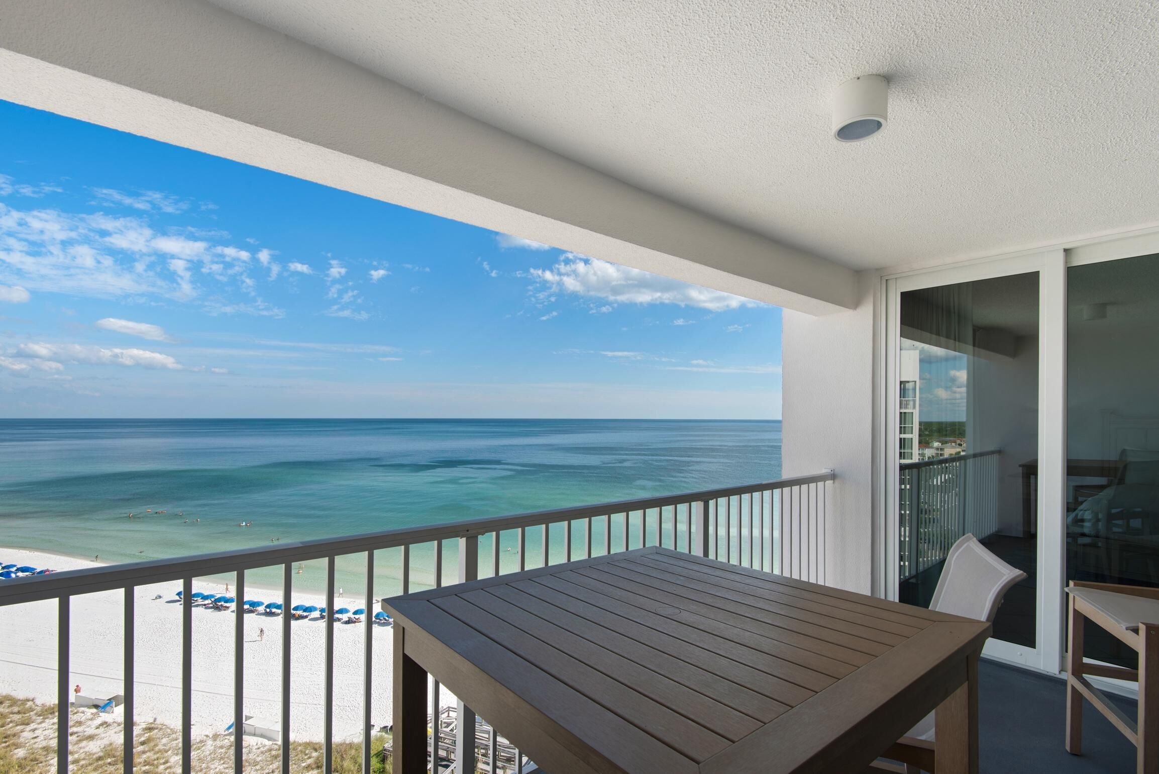 A balcony with a view of the ocean and beach.