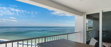A balcony with a view of the ocean and beach.