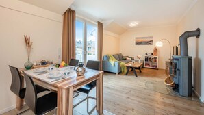 Un salon moderne comprenant un coin repas, un canapé, une cheminée et une vue sur la ville.