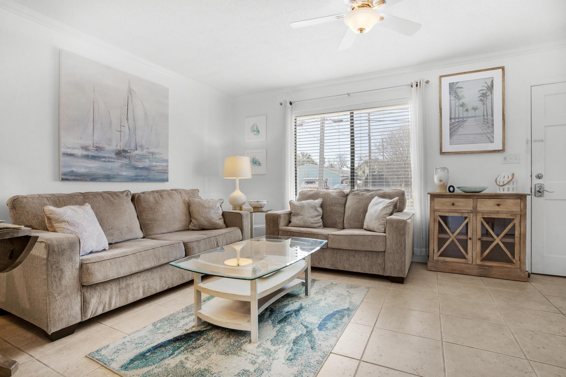 A living room with two sofas, a glass coffee table, a lamp, and a wooden cabinet.