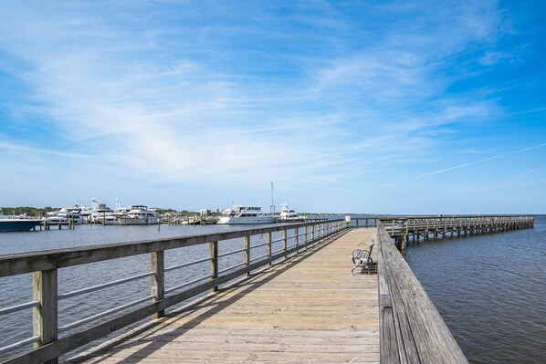 A wooden pier extending into calm water with boats docked at the end. - Bayside at Sandestin 6770 (Miramar Beach)