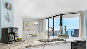 Una cucina moderna con un'ampia finestra, una macchina per caffè e un espositore per piatti.
