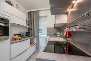 A compact kitchen with a microwave, sink, and stainless steel appliances.