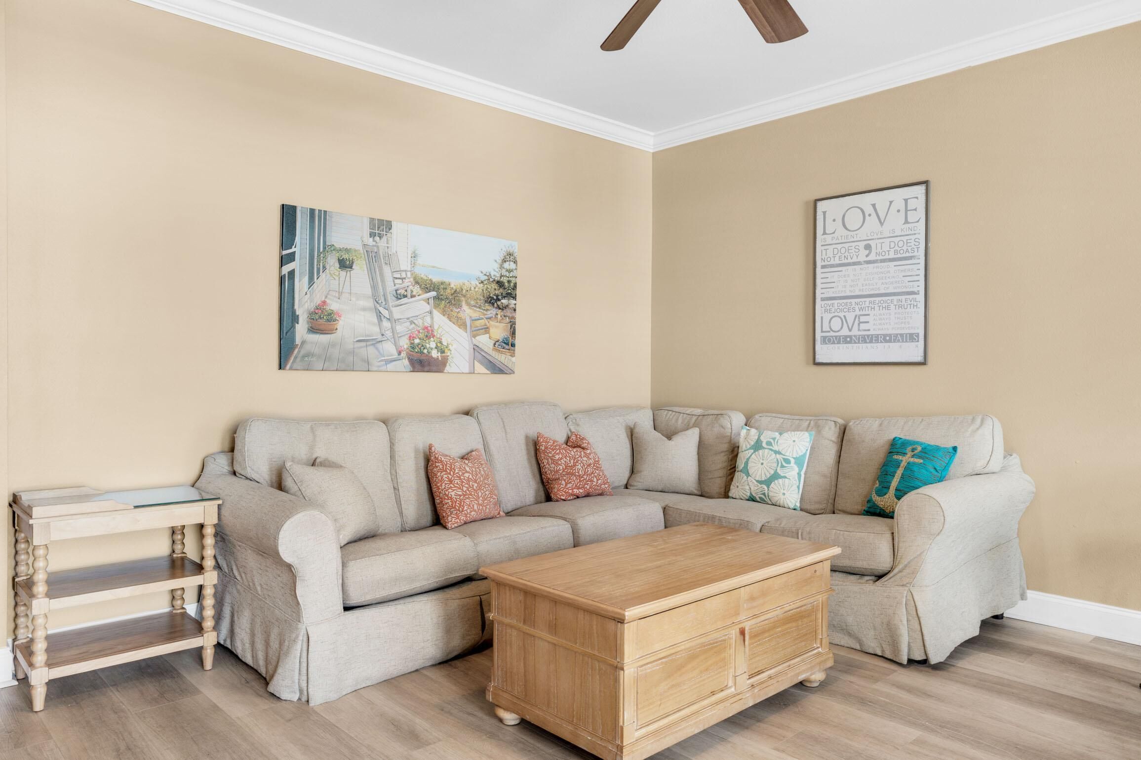 A living room with a beige sofa, a wooden coffee table, and a painting on the wall.