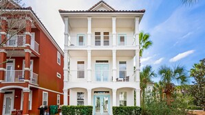 A two-story building with a white facade and blue accents, featuring balconies and a central entrance. - Changes in Latitude VCB (Destin)