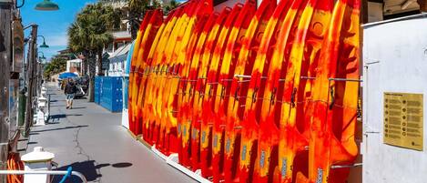 A row of red and yellow surfboards mounted on a wall.