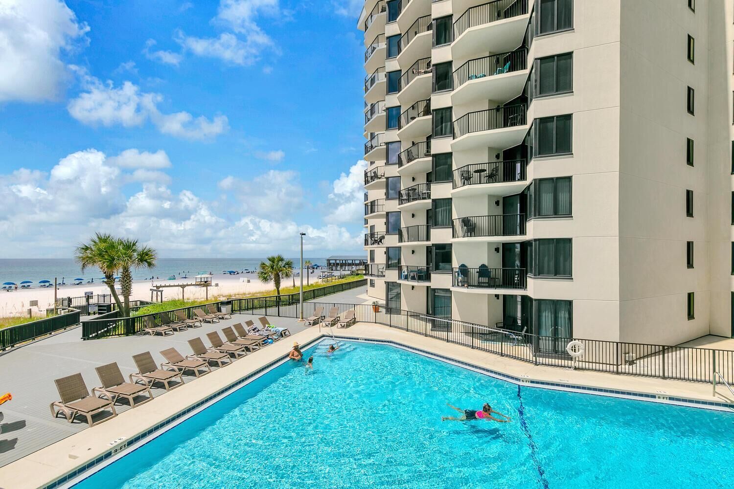 Ein Hotelpool mit Blick auf Strand und Meer.