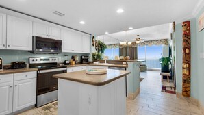 A modern kitchen with white cabinets, stainless steel appliances, and a central island. - Majestic Beach Towers 2-1305 (Panama City Beach)