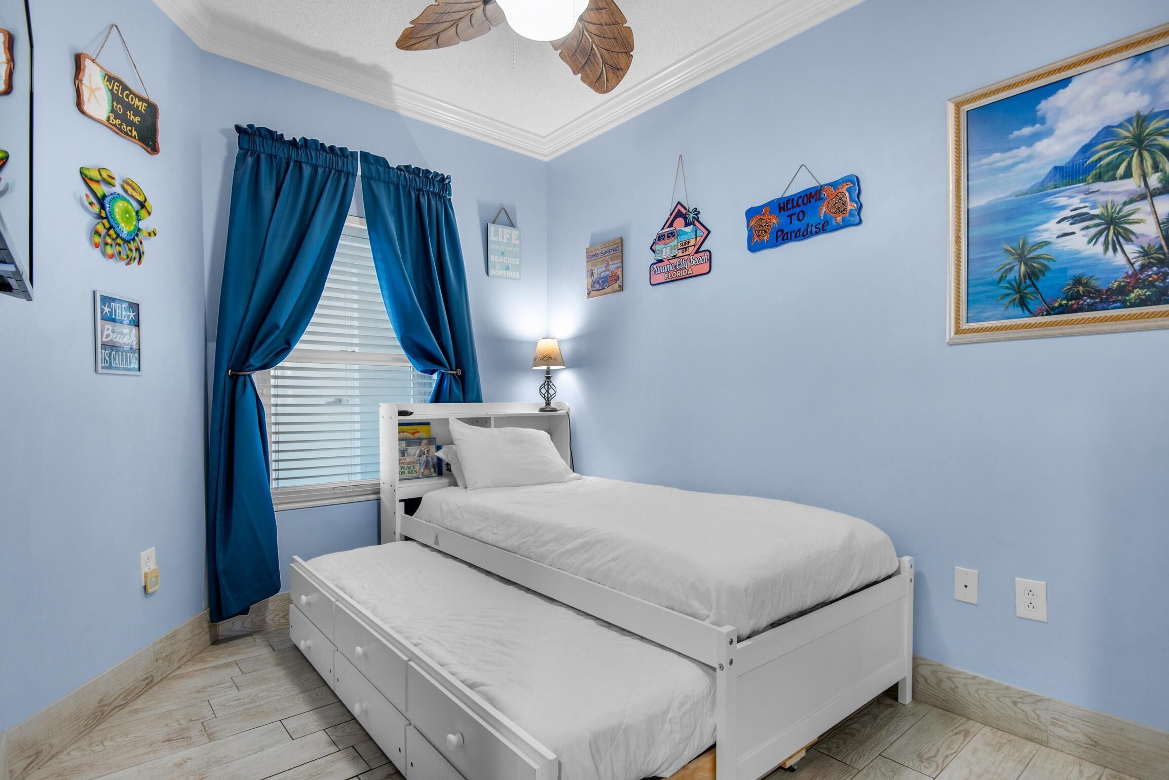 Une chambre à coucher avec un lit, une table de chevet, une lampe et une fenêtre avec des rideaux.