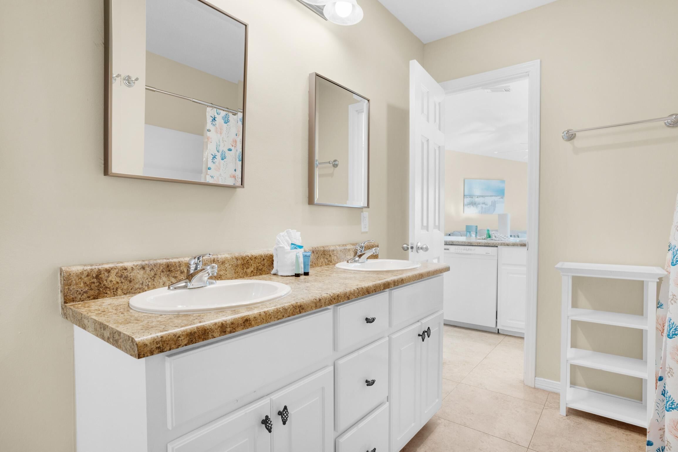 A bathroom with two sinks, a mirror, and a shower area.