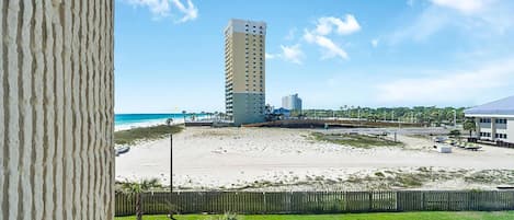 A tall building with a beach in the background.