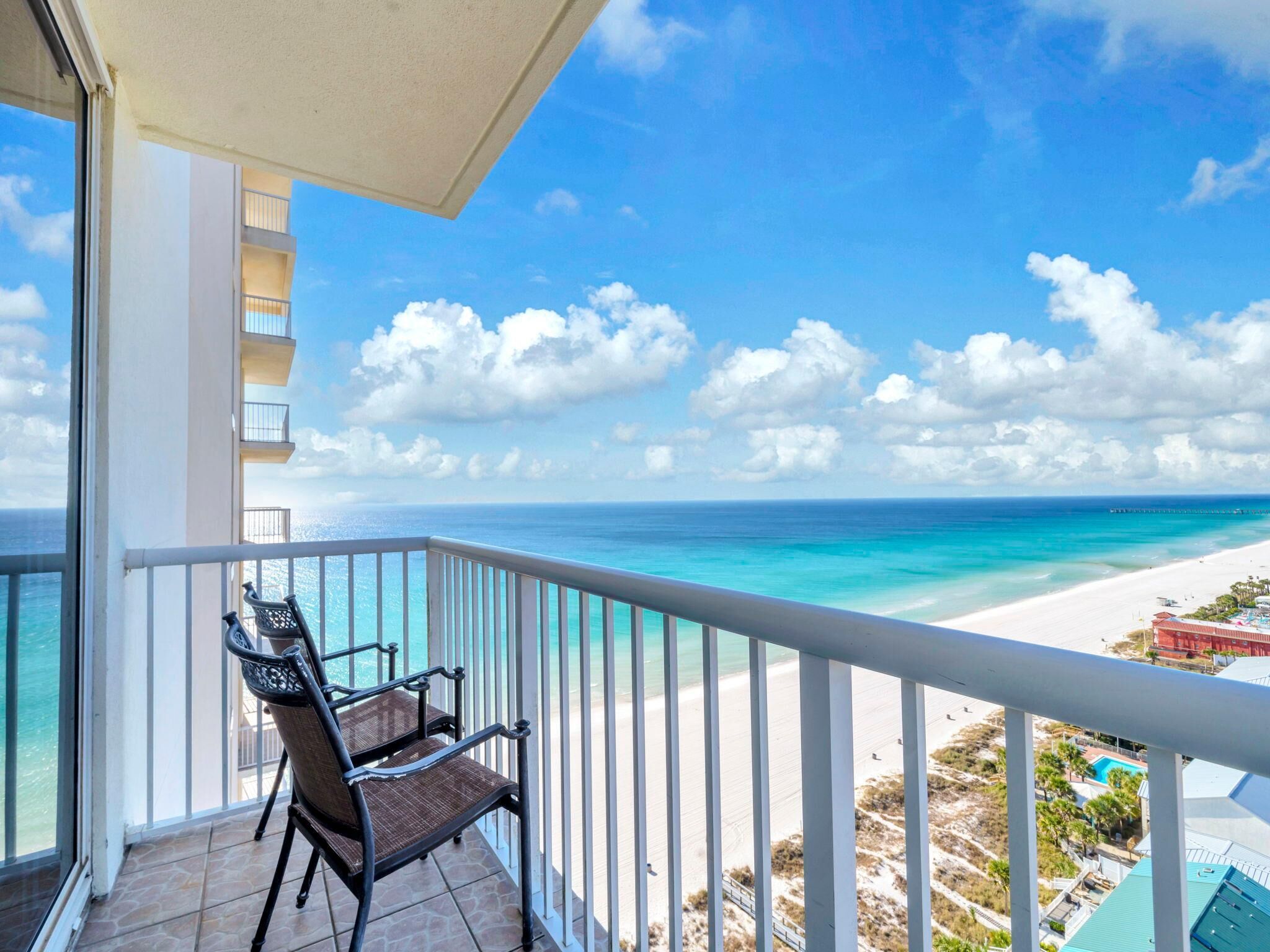 A balcony with a view of a beach and ocean.