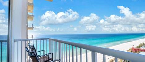 A balcony with a view of a beach and ocean.