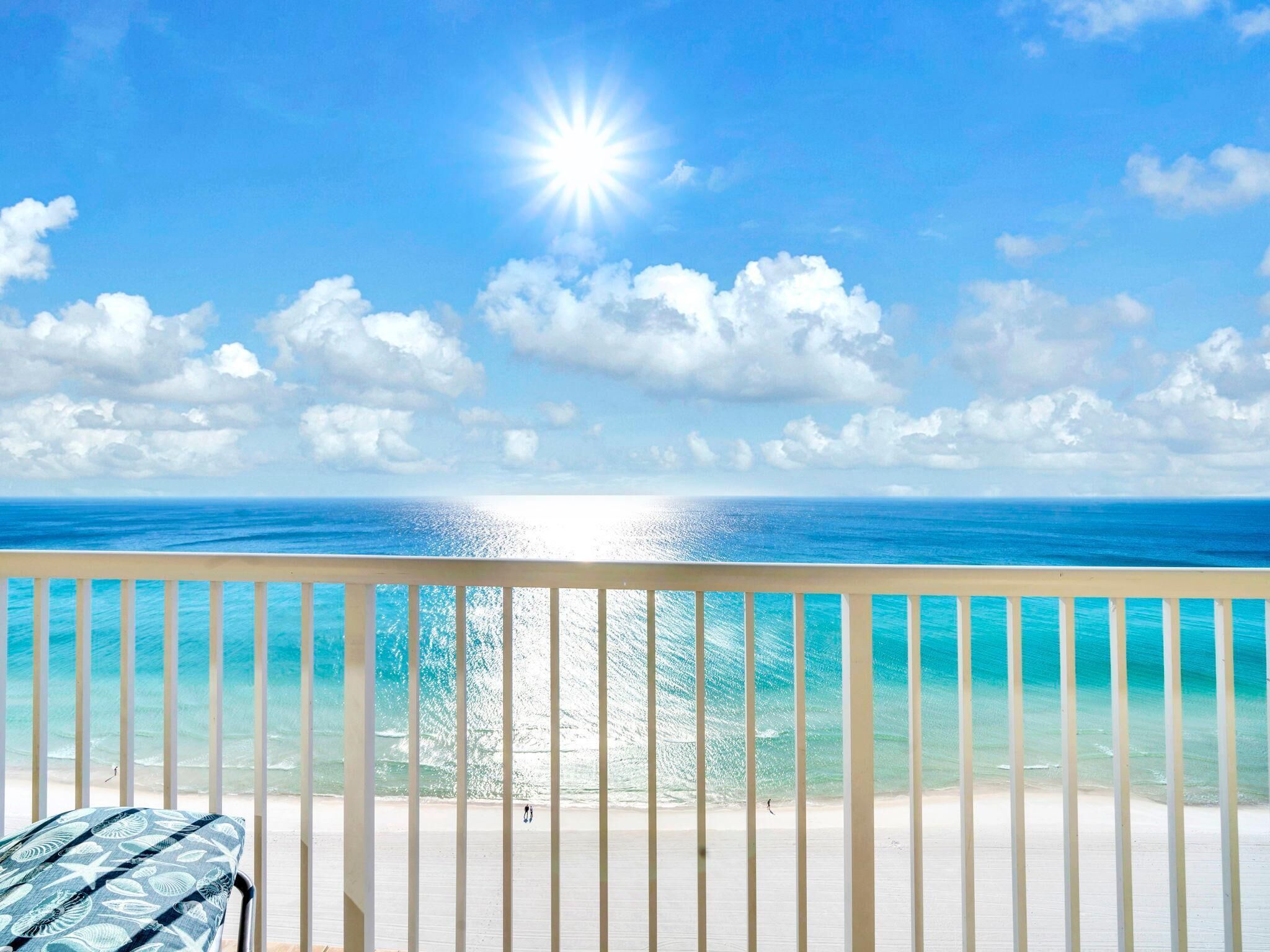 A balcony with a view of the ocean and beach.