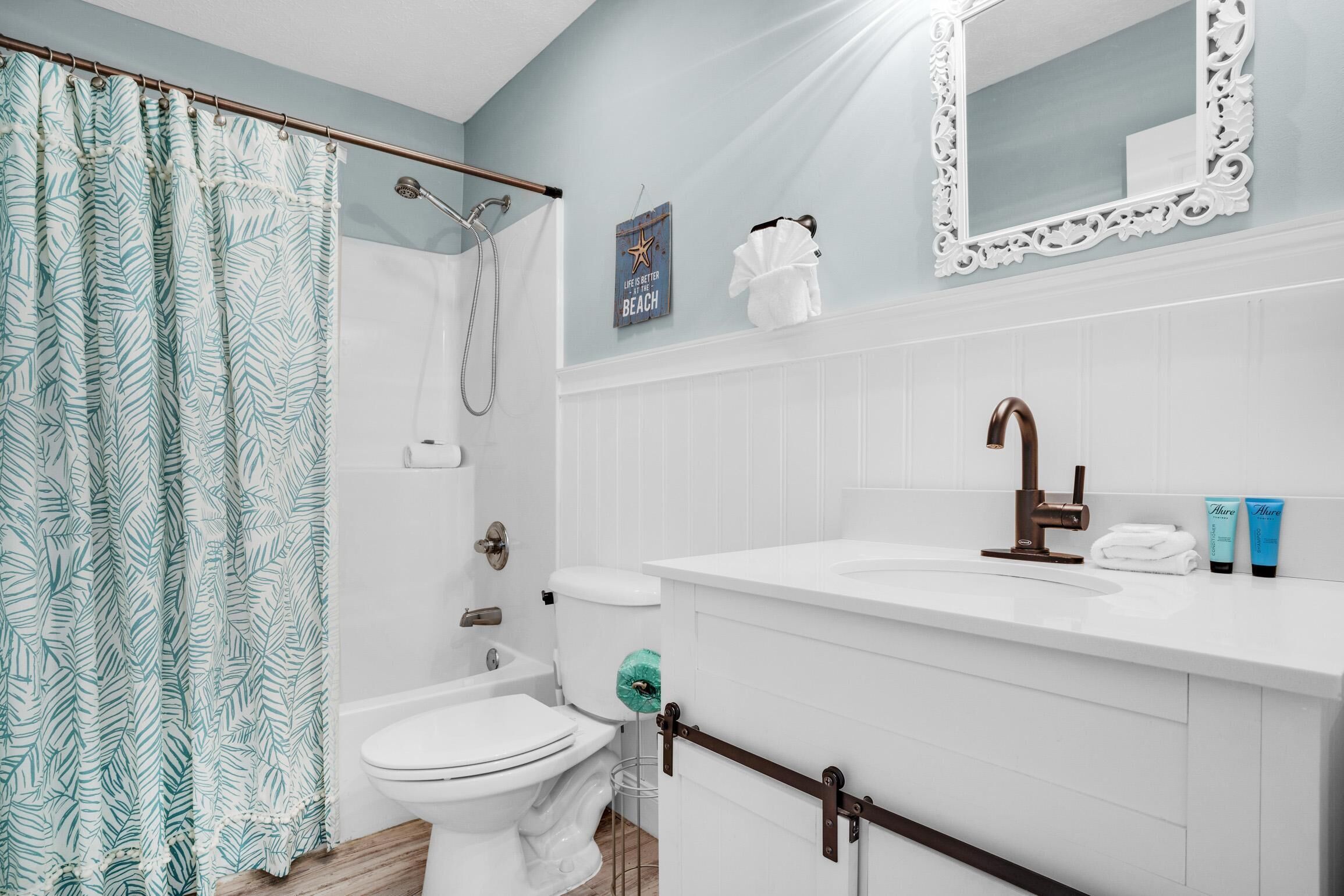 A bathroom with a shower, toilet, and sink.