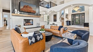 A spacious living room with a fireplace, leather sofas, and a coffee table. - 3 Miles from Bell Rock| Hot Tub| Pool Table| Sleeps 14 (Sedona)