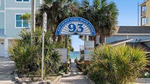 A pathway leading to a beach entrance with a sign reading "Bay County Public Beach Access 93". - Bella Costa 160- Sandy Feet Retreat (Panama City Beach)