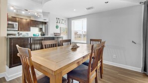 A modern kitchen with dark wooden cabinets, a granite countertop, and stainless steel appliances.