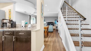 A modern kitchen with dark cabinets, a granite countertop, and a coffee maker.
