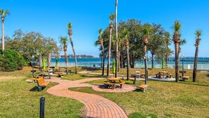 Ein Park mit Picknicktischen, Bänken und einem gepflasterten Weg.